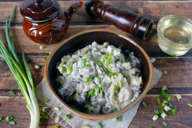 Oyster mushrooms in sour cream in a frying pan