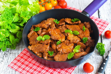 Pork meat in soy sauce in a frying pan