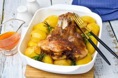 Pork knuckle baked with potatoes in the oven