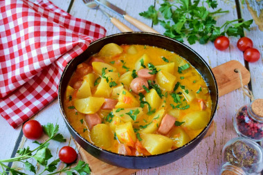 Stewed potatoes with sausages in a frying pan