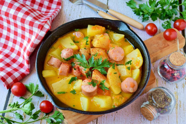 Stewed potatoes with sausages in a frying pan