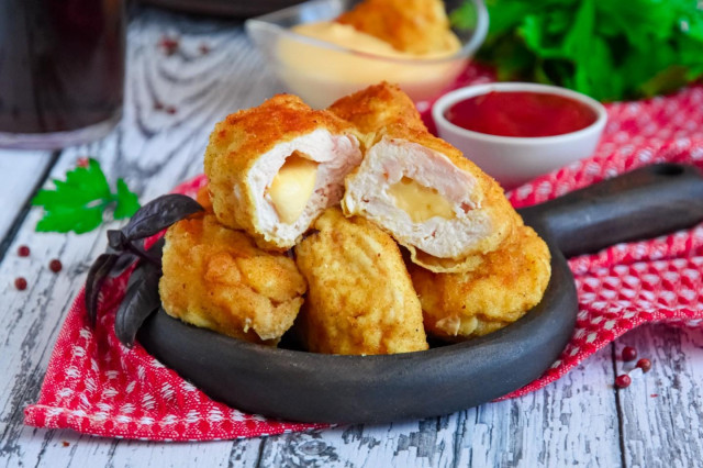 Chicken nuggets with cheese in a frying pan