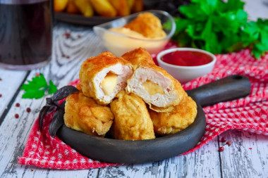 Chicken nuggets with cheese in a frying pan