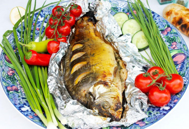 Carp in foil on coals