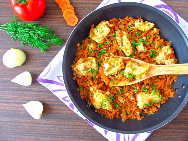 Chicken breast with carrots and onions on frying pan