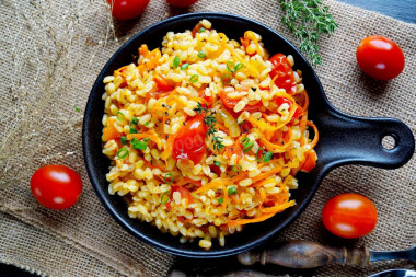 Bulgur with onions and carrots in a frying pan