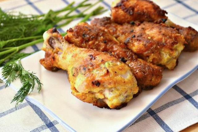 Chicken legs in batter in a frying pan