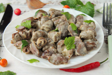 Stewed chicken hearts in sour cream in a slow cooker