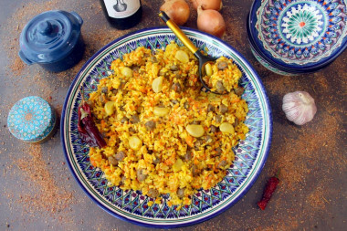 Pilaf with chicken hearts in a cauldron