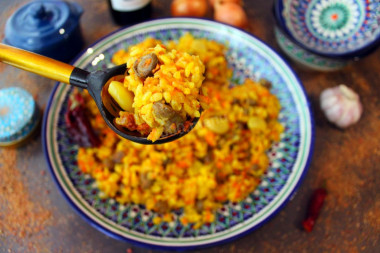 Pilaf with chicken hearts in a cauldron