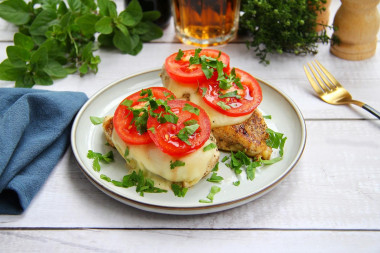 Chicken fillet with tomatoes and cheese in a frying pan