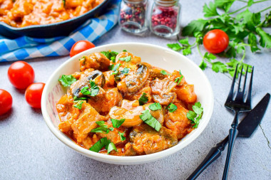 Pork with mushrooms in a frying pan in sauce with onions