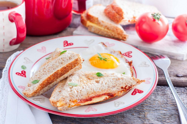 Hot sandwiches with sausage, tomato and cheese in a multi-bakery