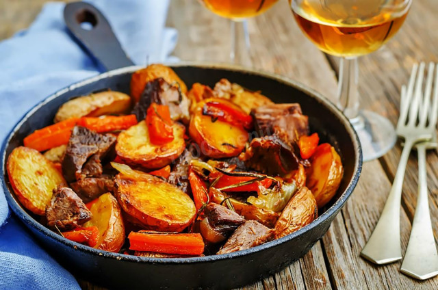 Potatoes with meat and onions in a frying pan