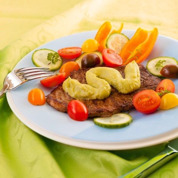 Meat with avocado in a frying pan