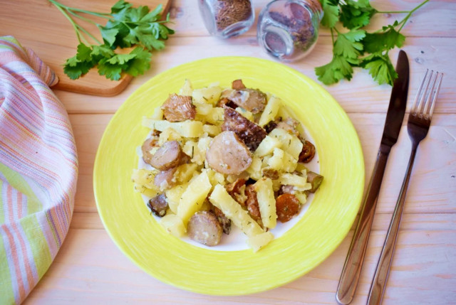 Potatoes with mushrooms in a frying pan with sour cream