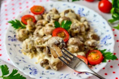 Mushrooms in cream with cheese in a frying pan