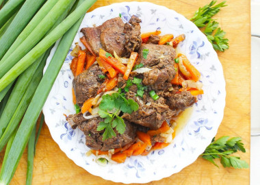 Stewed hare with vegetables and garlic in a frying pan