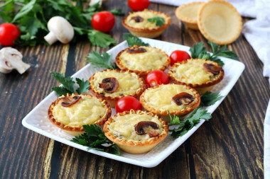 Julienne with mushrooms in tartlets in the oven