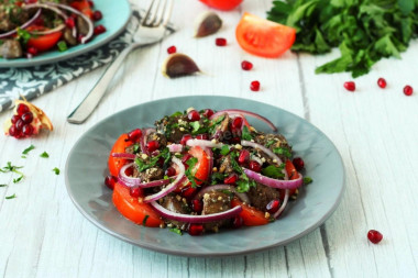 Salad with chicken liver and tomatoes, nuts and pomegranate