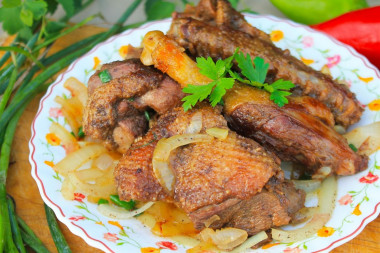 Duck in a cauldron on a fire with onions