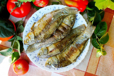 Crucian carp on coals in foil with sour cream