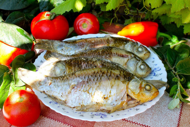 Crucian carp on coals in foil with sour cream