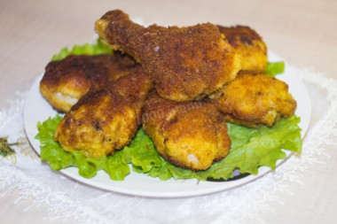 Chicken legs in breadcrumbs in a frying pan