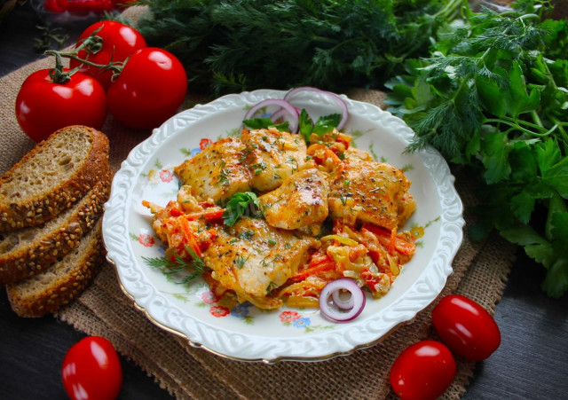 Pangasius with vegetables and sour cream in a frying pan