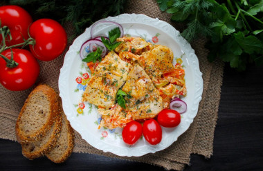 Pangasius with vegetables and sour cream in a frying pan