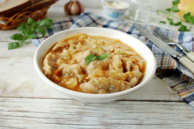 Pork with sour cream, onion, carrots in a frying pan