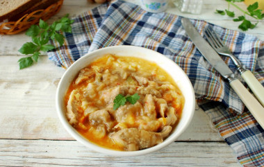 Pork with sour cream, onion, carrots in a frying pan