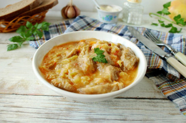 Pork with sour cream, onion, carrots in a frying pan