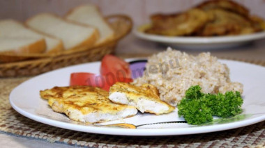 Chicken chops in sour cream batter in a frying pan