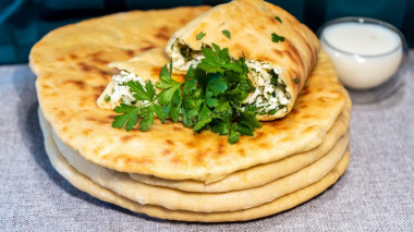 Kefir tortillas with suluguni and green onions in a frying pan