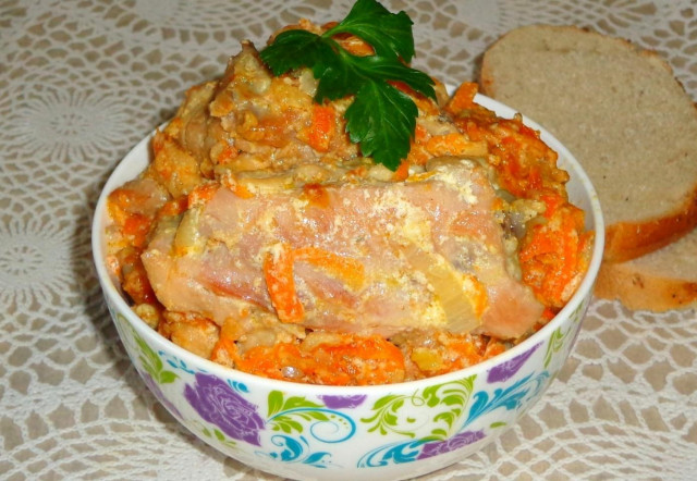 Chicken stewed in a saucepan with sour cream and carrots