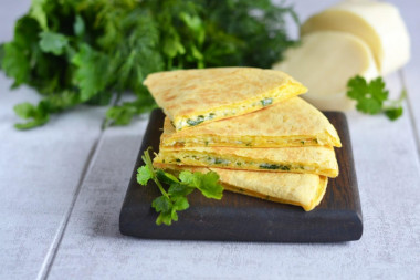 Tortilla with cheese and egg in a frying pan