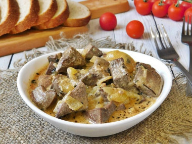 Pork liver in sour cream with onions in a frying pan