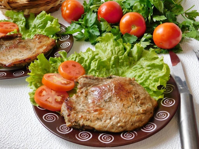 Pork steak with soy sauce in a frying pan