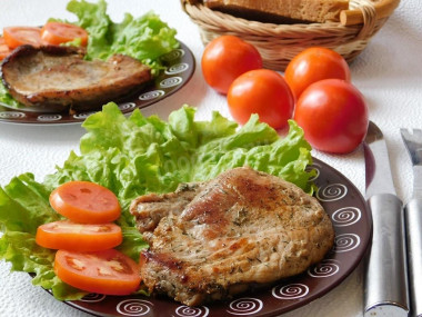 Pork steak with soy sauce in a frying pan