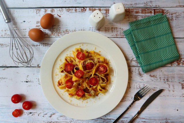 Omelet strips with cherry, bacon slices and grated cheese