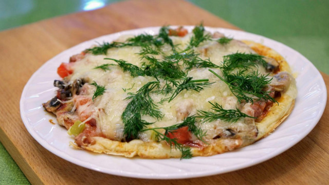 Quick pizza with tomatoes, cheese and mushrooms in a frying pan