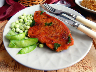 Pork steak in a frying pan with black pepper