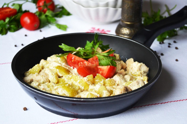 Chicken fillet in sour cream in a pan with zucchini and curry