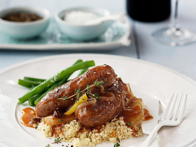 Kupaty with gravy in a frying pan