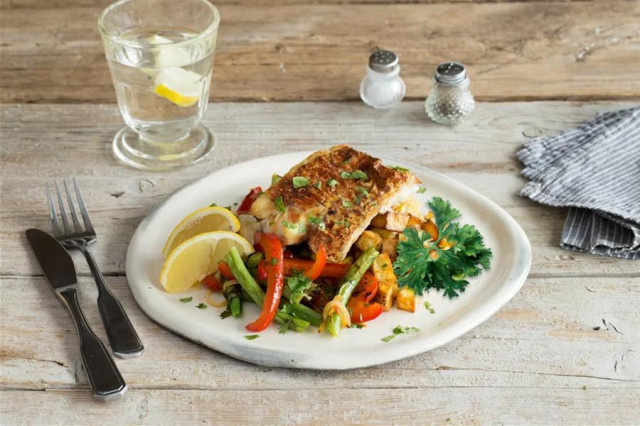 Sea whitefish with vegetables in a frying pan