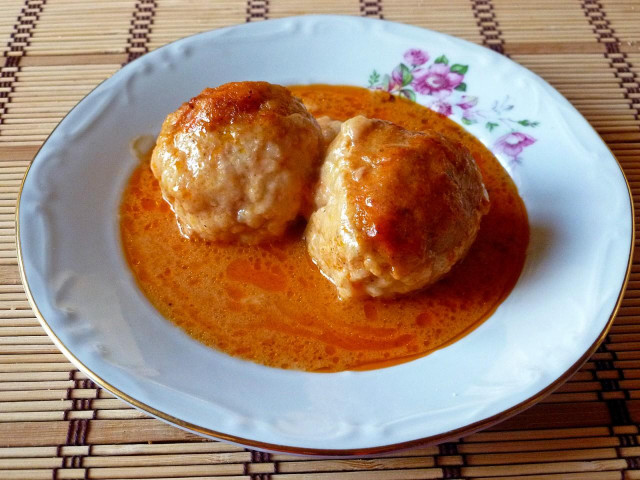 Pork meatballs in a saucepan with rice and gravy