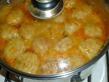 Pork meatballs in a saucepan with rice and gravy