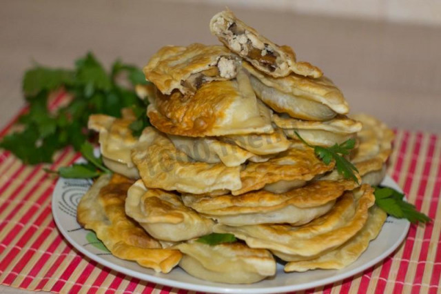 Quick dough pies in a frying pan with mushrooms and chicken