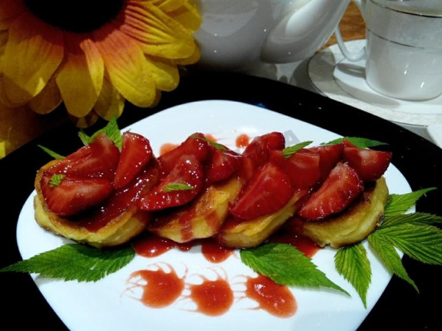 Cheesecakes with strawberries and strawberry syrup